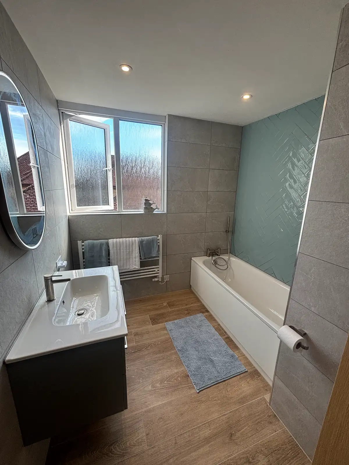 Completed bathroom with bath and vanity unit