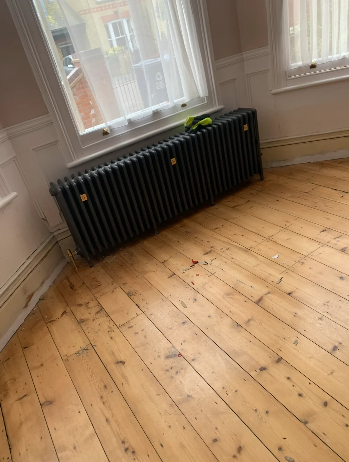 Black column radiator fitted on a wooden floor